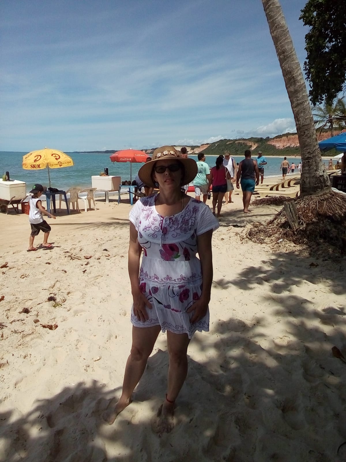 mulher feliz posando na praia em Arraial d'Ajuda, cliente da Suez Turismo