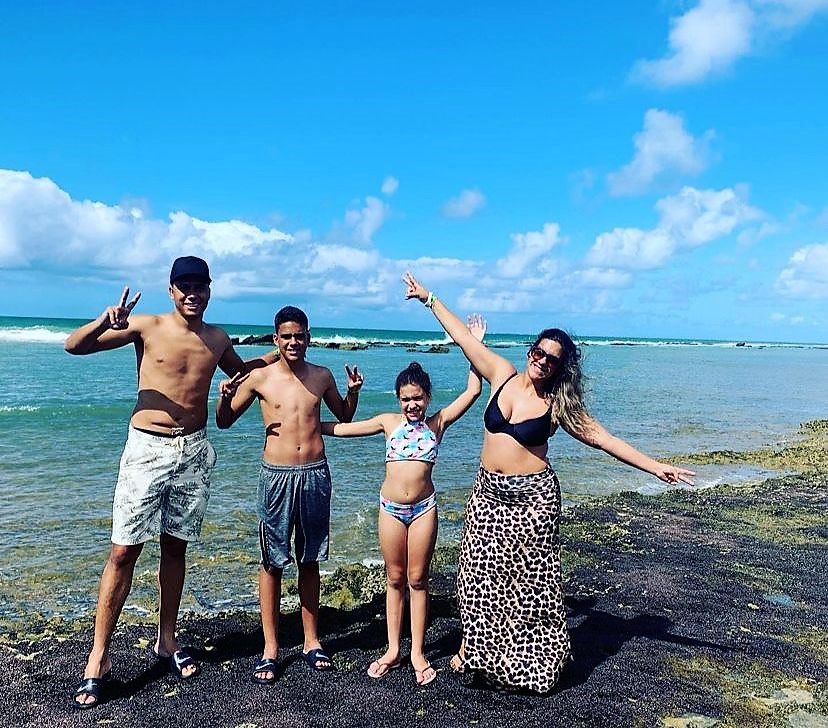 familia de quatro pessoas, casal com um filho adolescente e uma menina, felizes a beira mar de maceio. Clientes da Suez Turismo